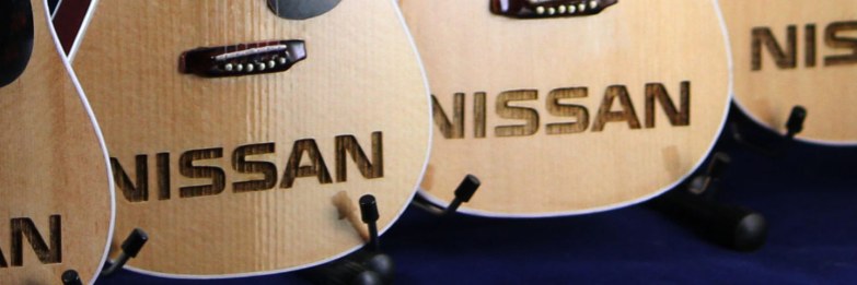 Closeup of Nissan Logo Laser-Engraved into AXE HEAVEN® Acoustic Mini Guitar Promotional Item